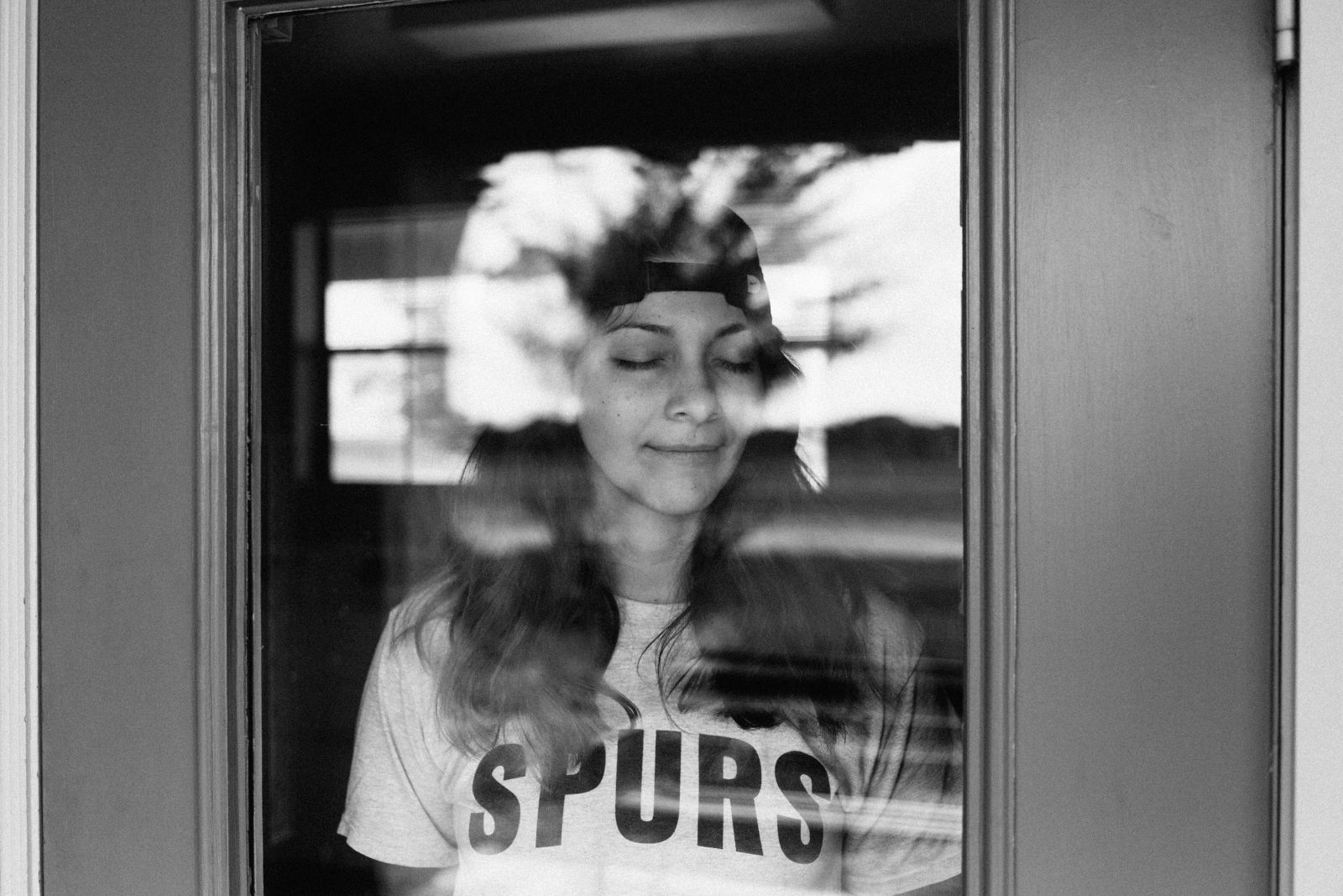 Mulher branca de boné e olhos fechados.