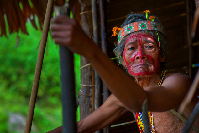 Um homem indígena segurando um bambu