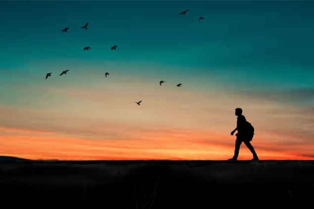 Silhueta de um homem caminhando durante o pôr do sol