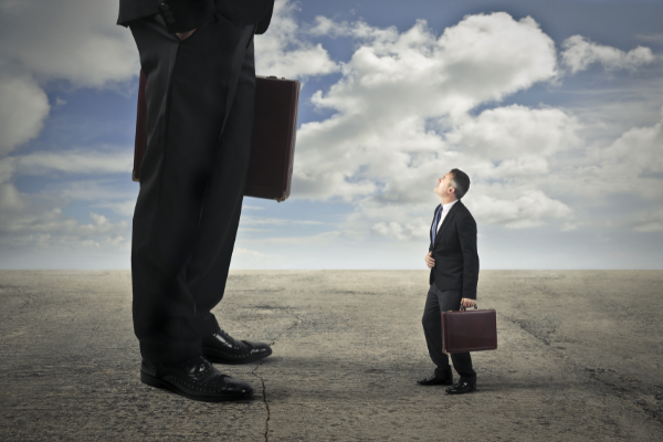 Um gigante conversando com uma anão de terno