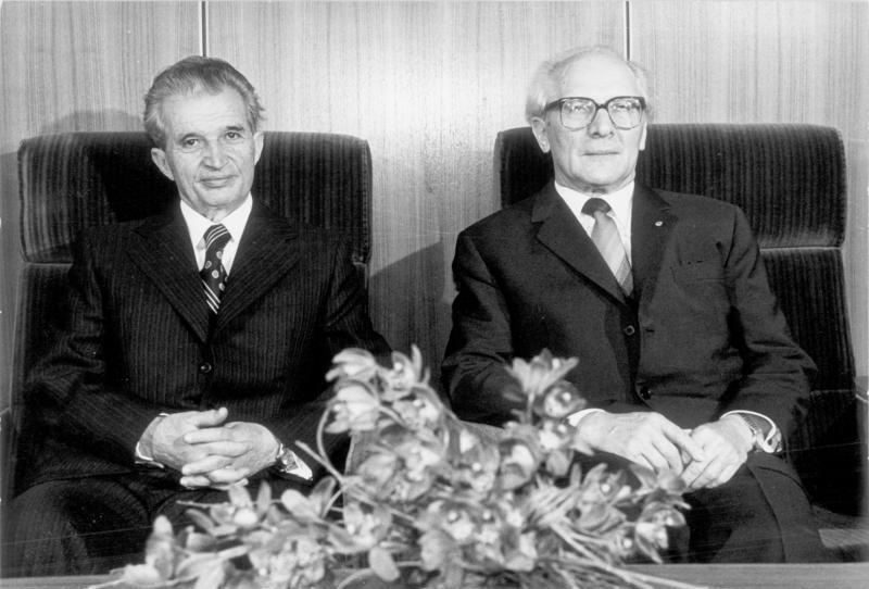 Nicolae Ceausescu sentado em um poltrona ao lado de outro homem