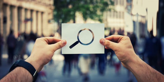 Pessoa segurando símbolo de pesquisa