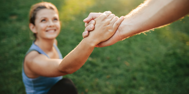 Pessoa ajudando mulher a levantar