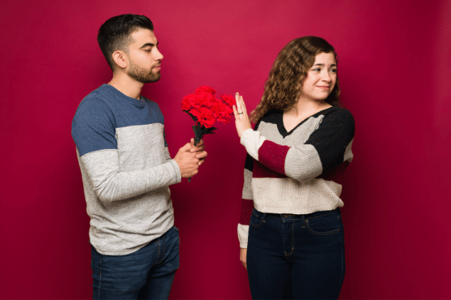 Antonio_Diaz / Getty Images / Canva Pro Mulher ignorando flores e declaração romântica de homem.