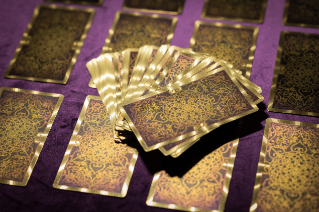 Algumas cartas de Tarot viradas para baixo estão em destaque na imagem.