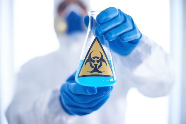 Imagem de um cientista com um vidro na mão e um símbolo de tóxico rotulando o vidro