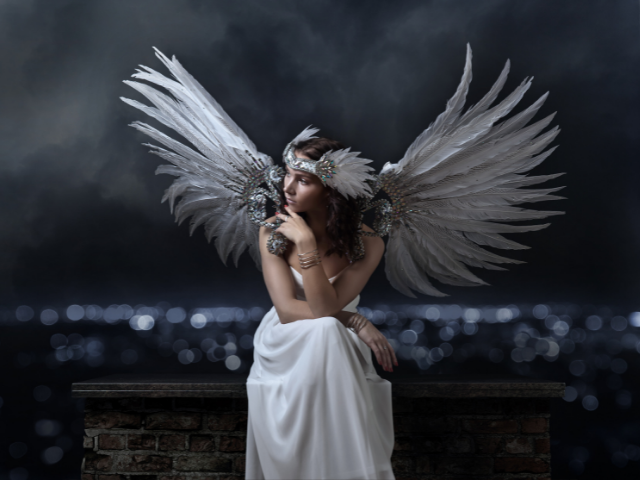 Anjo de asas brancas sentado 