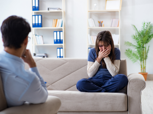 Vítima de estupro sentada em sofá em frente a familiar