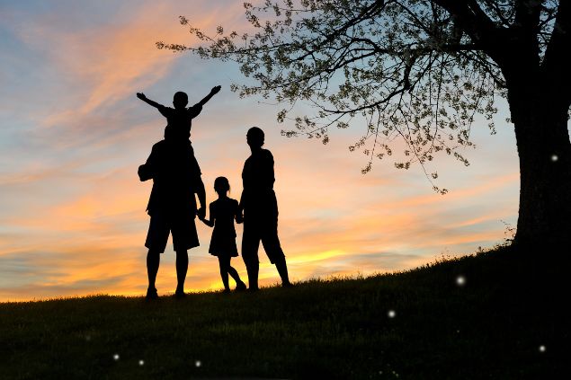 Família ao pôr-do-sol embaixo de uma árvore