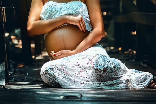 Mulher grávida sentada no chão