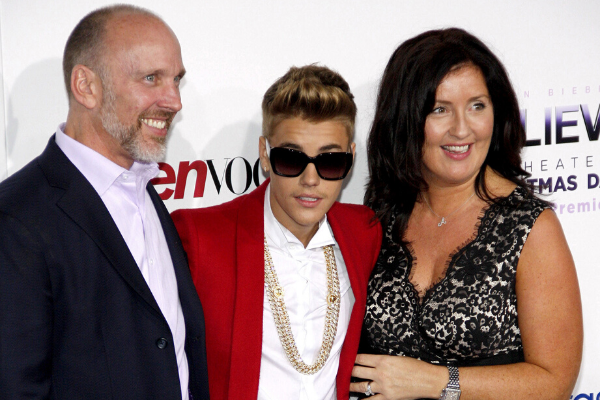 Justin Bieber usando óculos de sol ao lado de sua família em uma premiaçãp