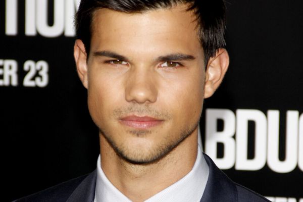 Taylor Lautner olhando para frente usando terno e gravata