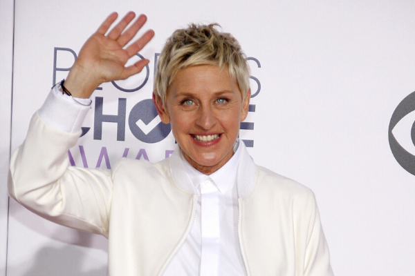 Ellen DeGeneres usando camisa e jaqueta acenando e sorrindo