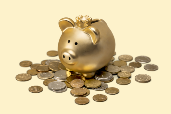 Imagem de um cofre dourado em formato de porco com moedas ao redor