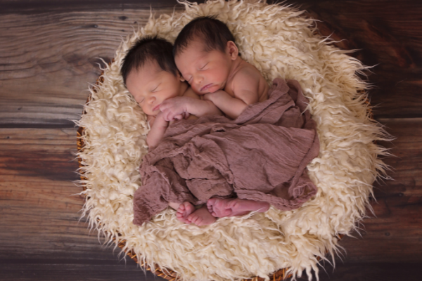 Imagem de dois bebês gêmeos recém-nascidos dormindo