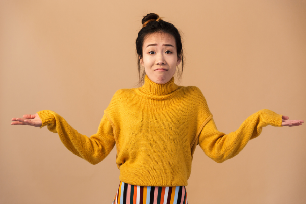 Dean Drobot / Canva Mulher com os braços abertos e expressão de inocência