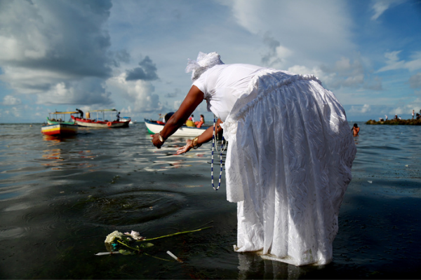 Mulher jogando oferenda no mar para Iemanjá