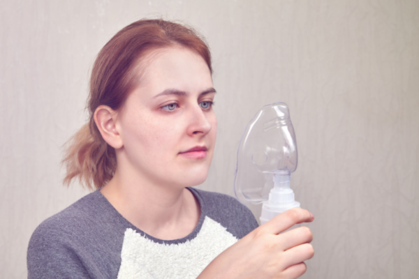 Grigorev_Vladimir / Getty Images / Canva Mulher segurando um inalador