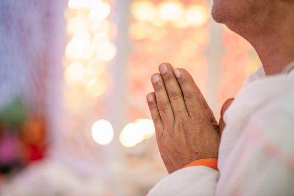 Pessoa mais velha com as mãos juntas em sinal de oração
