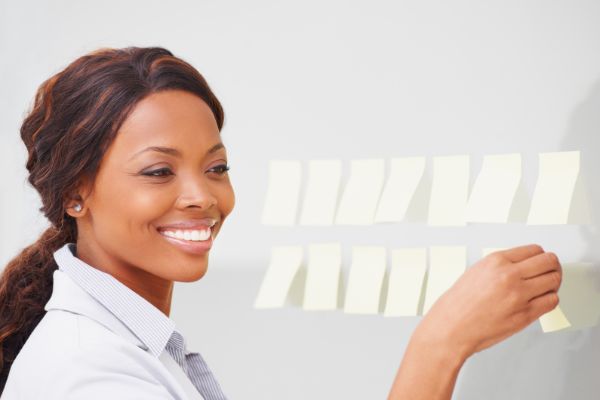 Mulher sorrindo e organizando post-its