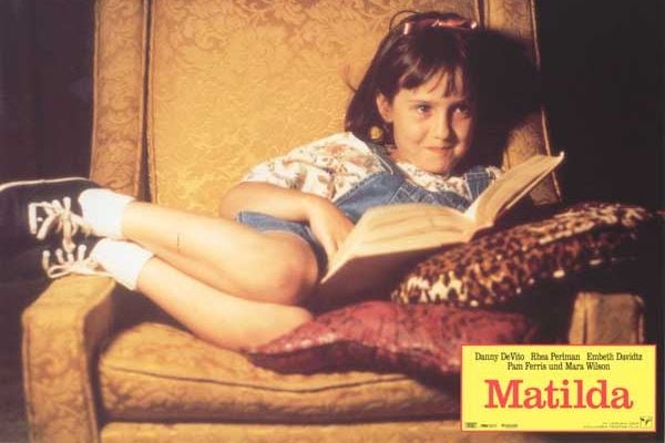 Poster do filme com a personagem Matilda sentada na poltrona lendo um livro