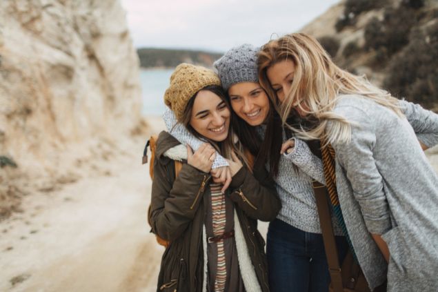 Imagem de três amigas abraçadas ao ar livre