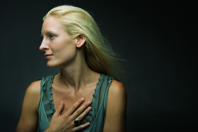 Imagem de uma mulher olhando para o lado e com a mão no coração