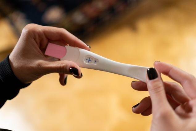 Imagem de uma mulher segurando um teste de gravidez