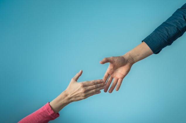 Imagem de uma mão estendida para a outra em um fundo azul