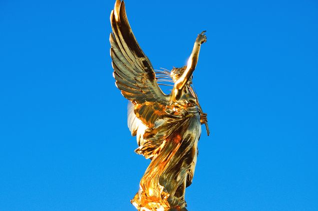 nevenmn de Getty Images/ Canva Imagem da estátua de um anjo dourado com uma das mãos erguida ao céu