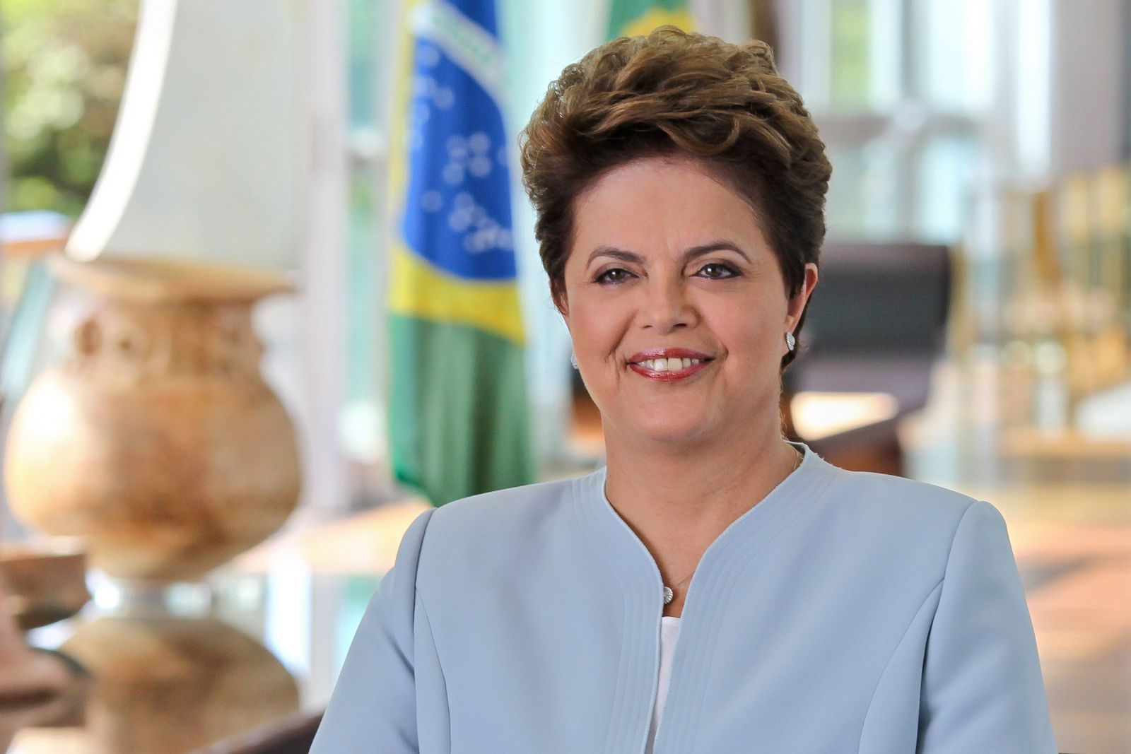 Dilma Rousseff sorrindo no seu escritório 