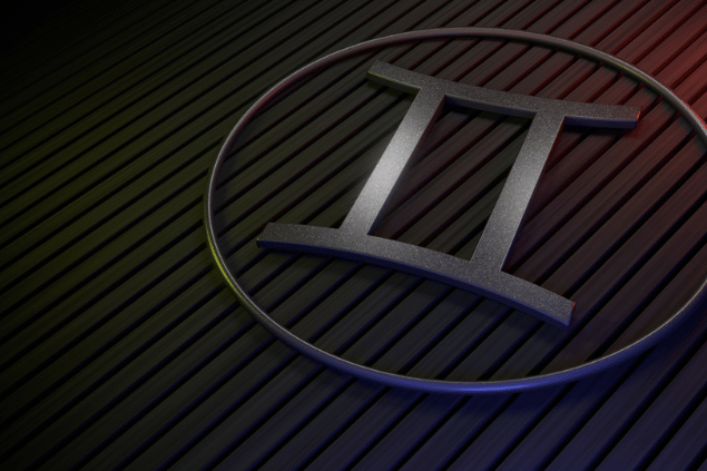 Símbolo do signo de Gêmeos em relevo metálico dentro de um círculo, sobre fundo escuro com linhas diagonais.