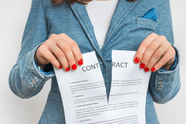 andriano_cz / Getty Images / Canva Pro Mulher de negócios rasgando contrato.