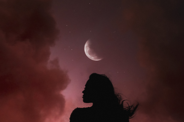 Silhueta de uma mulher diante de uma Lua Cheia