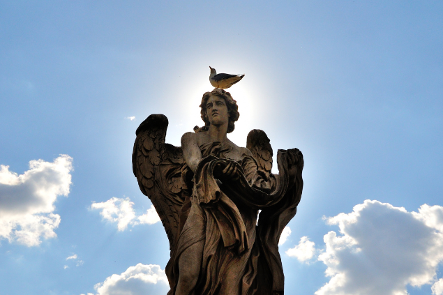 Estátua de anjo com um pássaro na cabeça