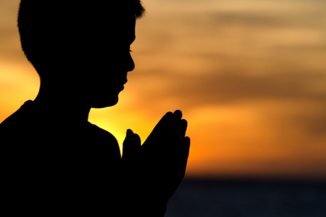 Silhueta de uma criança orando