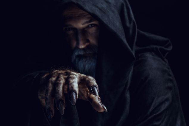 Imagem de um homem de barba e bigode, usando uma capa preta, simbolizando o Exu Marabô.