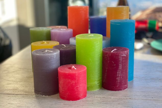 Imagem de vários tipos, cores e tamanhos de velas, uma das oferendas para o Exu Mirim.