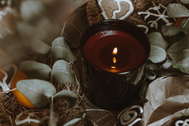 Imagem de uma vela marrom acesa, simbolizando uma das oferendas feitas para a entidade Zé do Morro.