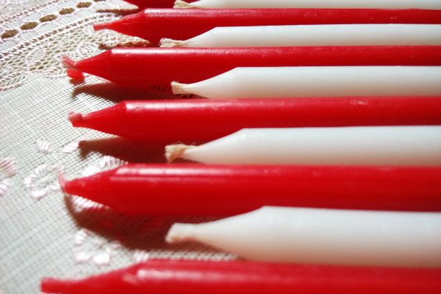 Imagem de várias velas nas cores: vermelha e branco, simbolizando uma das oferendas para a entidade Zé do Morro.