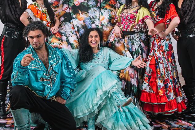 Imagem de várias ciganas e em destaque um casal de ciganos. Ela usa um lindo vestido verde água e ele uma blusa também na mesma cor, com brilhos em prateado. Ela simboliza a cigana Esmeralda da Umbanda.