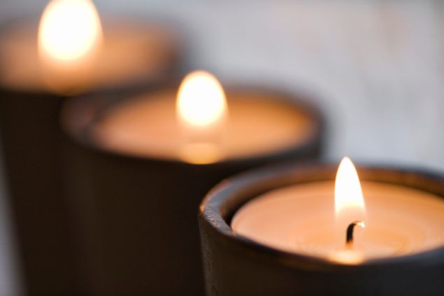 Jupiterimages / Photo Images / Canva Imagem de três velas pretas acesas, simbolizando uma oferenda para o Exu da Morte.