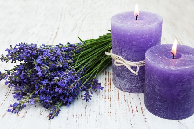 Imagem de duas velas na cor lilás e um arranjo floral de lavanda também na cor lilás, simbolizando uma das oferendas para a cigana Sara da Umbanda.