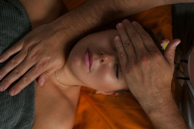 Imagem de um reikiano aplicando o reiki em uma paciente para melhorar o aspecto físico, emocional e mental.