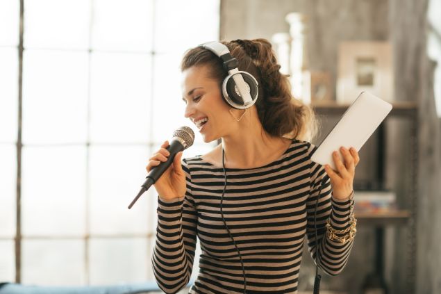 Alliance Images / Canva Imagem de uma mulher treinando e ensaiando a sua apresentação como mestre de cerimônias em um evento.