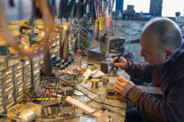 Kentarus / Getty Images Signature / Canva Imagem de um inventor soldando algumas peças sobre uma mesa de trabalho.