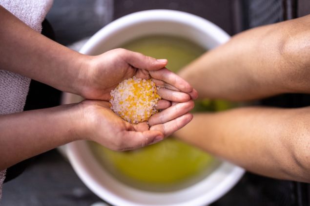 FG Trade / Getty Images Signature / Canva Imagem de uma pessoa se preparando para o ritual do batismo na Umbanda. Ela está se lavando com sais e ervas.