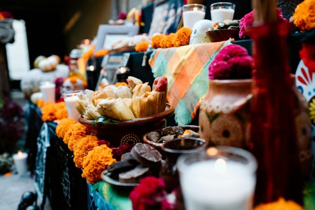 Bruno Cervera / Pexels / Canva Imagem de um altar com flores, alimentos, velas, tecidos e comidas que formam um santuário feito para as oferendas.