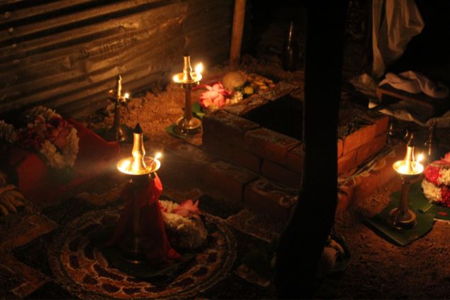 Imagem de um ritual de despacho feito no chão. O ritual inclui elementos como velas e flores.