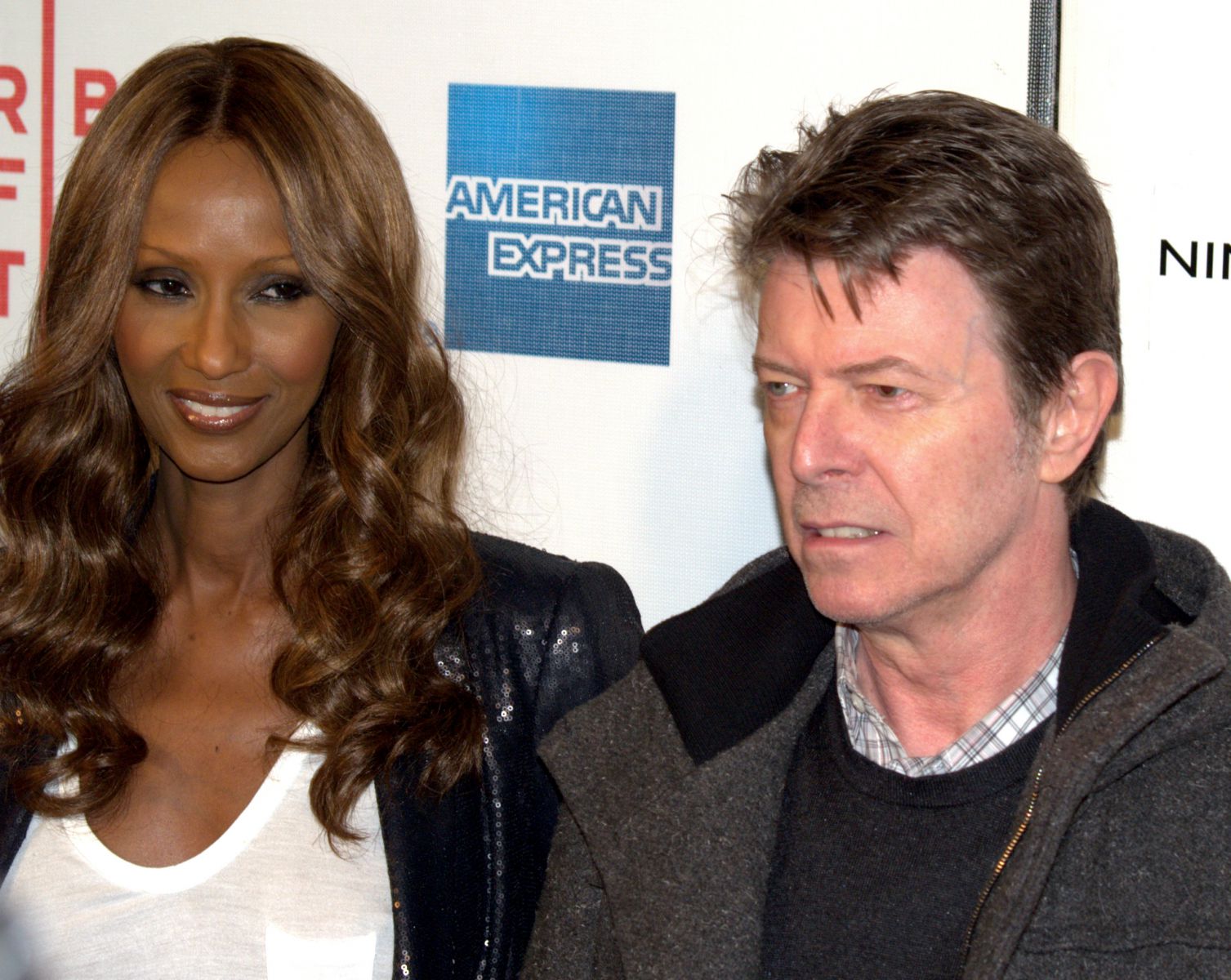 David Bowie olhando de lado ao lado de uma mulher em premiação